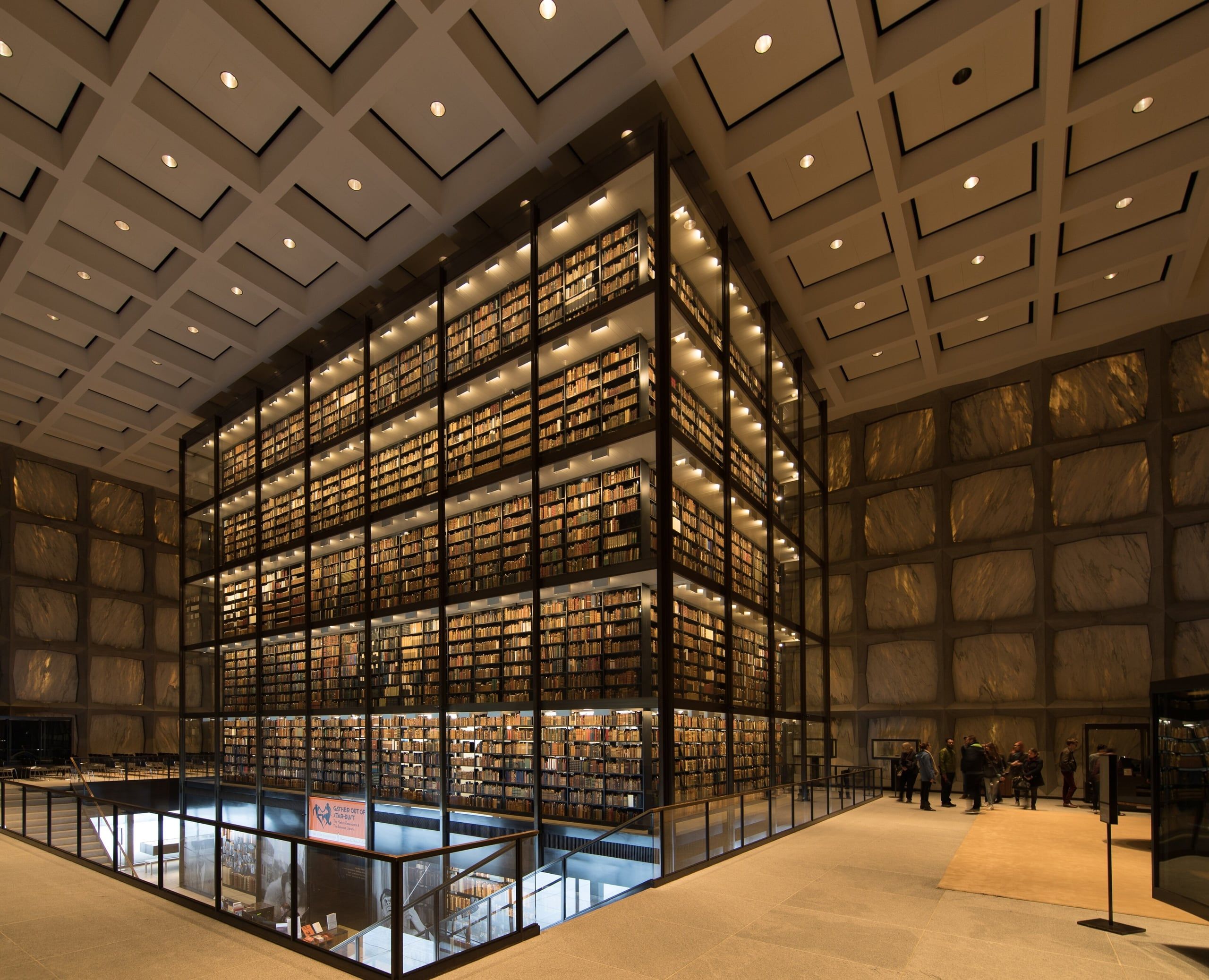 The glass book tower inside the Beinecke Library, lit through its marble walls
